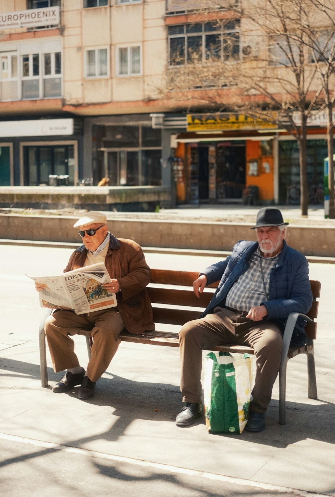 Croatian seniors reading a community newsletter together on a bench